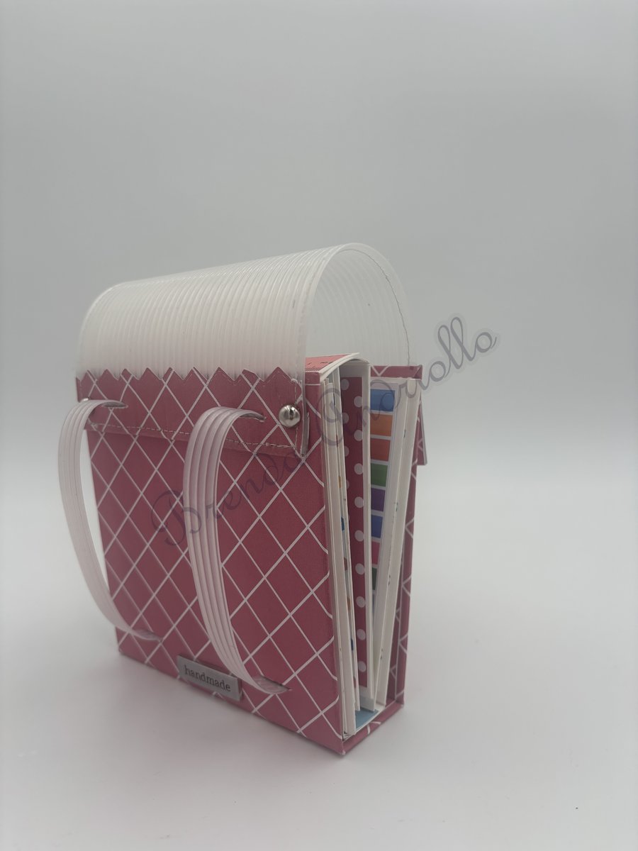 Album cartable ouvert de profil, pages dépliantes et bretelles, étiquette handmade