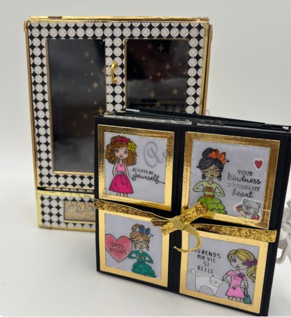 Coffret à damier noir et blanc ouvert sur quatre cartes illustrées et son ruban doré