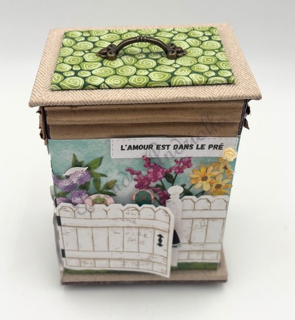 Boîte « L'amour est dans le pré » en cartonnage, barrière blanche et fleurs de printemps