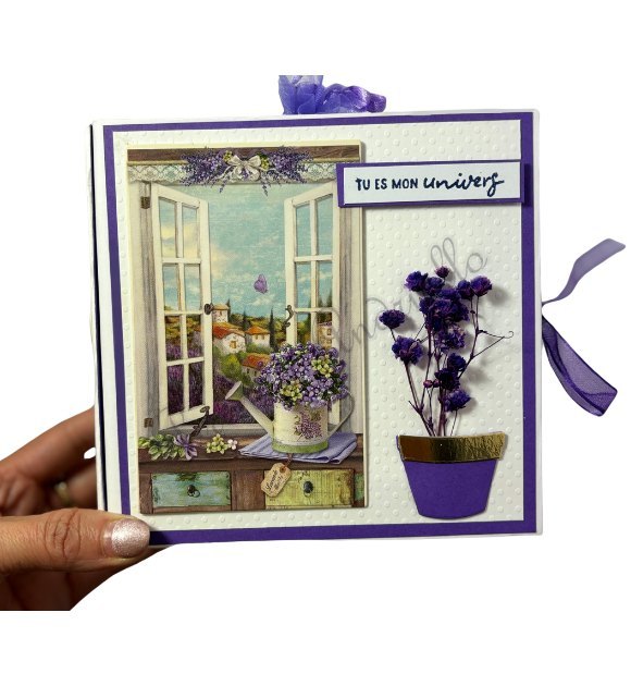 Carte violette « Tu es mon univers », fenêtre ouverte sur un jardin et pot de fleurs en relief